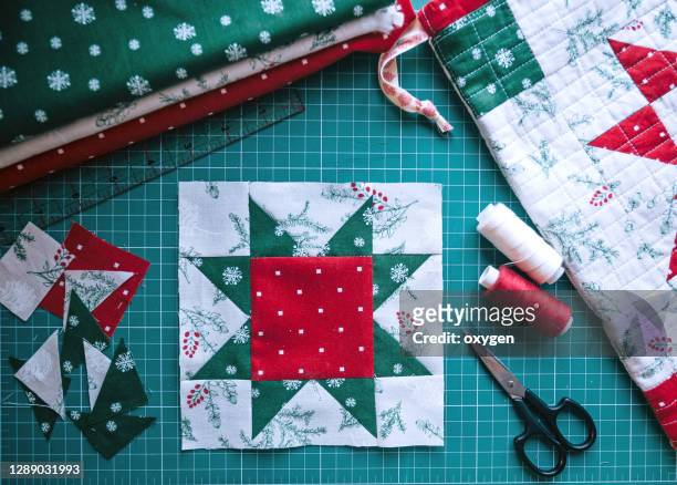 christmas patchwork red star block fragment of quilt, sewing accessories, space for text on green background - patchwork stock pictures, royalty-free photos & images