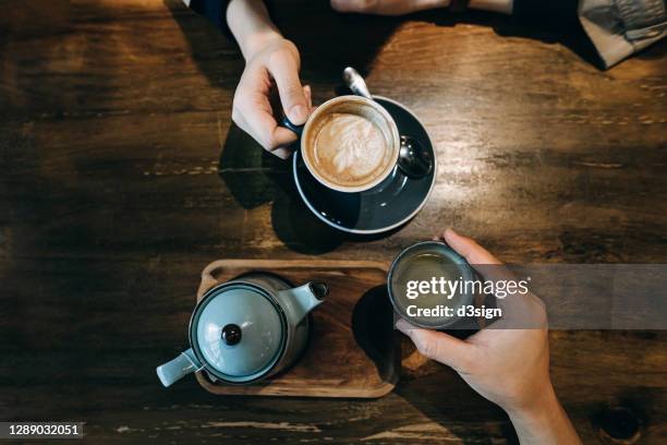 top view of young couple enjoying coffee and tea, sitting at rustic wooden dining table in a cafe, enjoying a relaxing moment - cup of tea from above fotografías e imágenes de stock