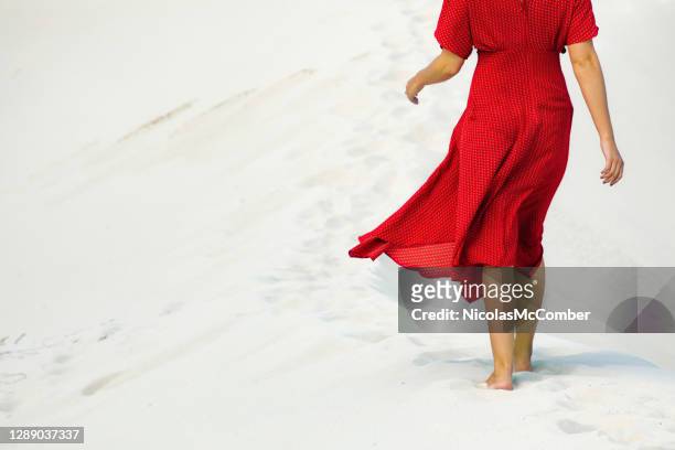 rear partial view of female walking barefoot in white sands dune - red dress imagens e fotografias de stock
