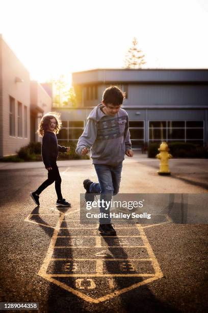 two kids playing hopscotch - hopscotch stock pictures, royalty-free photos & images