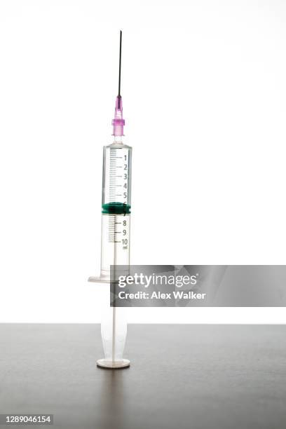 syringe with needle against white background - needle stock pictures, royalty-free photos & images