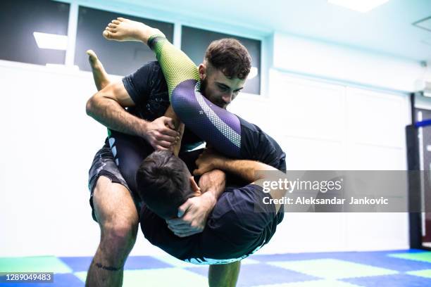 bjj instructors demonstrating a flying arm bar in class - jujitsu stock pictures, royalty-free photos & images