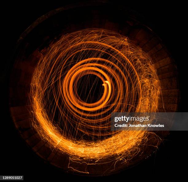 light sparks swirling in barrel - fire pit stockfoto's en -beelden