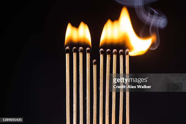 a line of matches on fire against a black background. - fire and brimstone stock-fotos und bilder