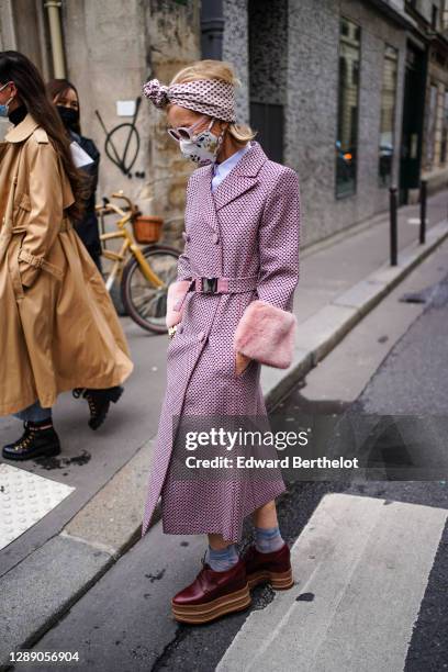 Guest wears a bandanna over the head, a floral print protective face mask, a shirt, a purple trench double breasted coat with six buttons printed...