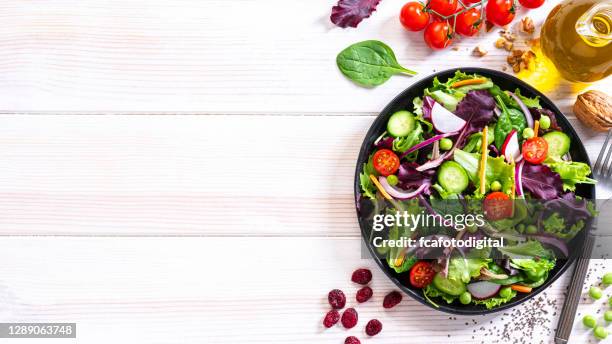 fresh vegetables salad plate on white table. copy space - salades stock pictures, royalty-free photos & images