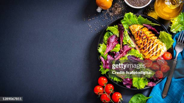 hühnersalatteller von oben auf dunklem hintergrund geschossen. kopierraum - gegrillte hühnerbrust stock-fotos und bilder