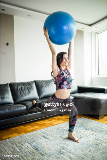 joven mujer en forma practicando en casa - yoga ball fotografías e imágenes de stock