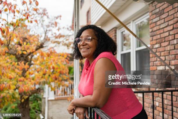 zwarte vrouw voor haar huis - nosotroscollection stockfoto's en -beelden