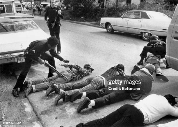 Police handcuff suspects in the killing of at least four persons during an anti-KKK rally. The confrontation left at least four dead and others...