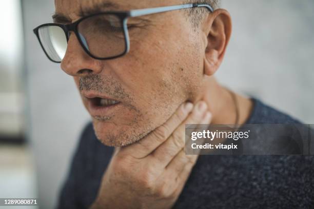 hombre mayor con dolor de garganta - throat photos fotografías e imágenes de stock