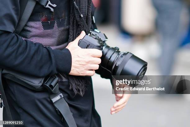 Photographer is seen using an Olympus OMD E-M1 X micro four-thirds M4/3 camera equipped with an Olympus M-Zuiko Pro 40-150mm F2.8 zoom lens, on...