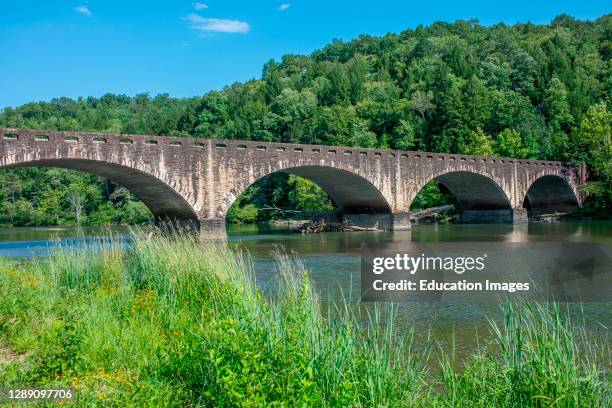 Historic Gatliff bridge, a stone covered concrete arch bridge over t he Cumberland River above the falls.