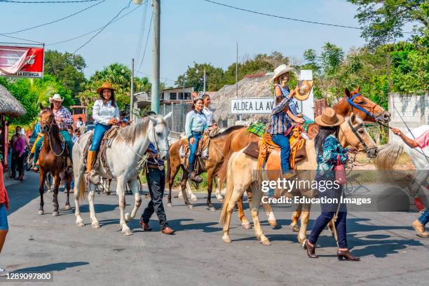 Riders on horseback in a parade through La Avellana, Guatemala.