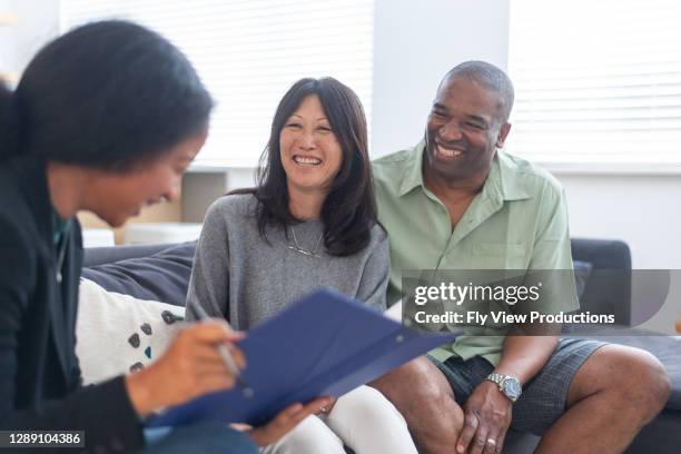 mixed race couple planning for early retirement - financial planning couple stock pictures, royalty-free photos & images