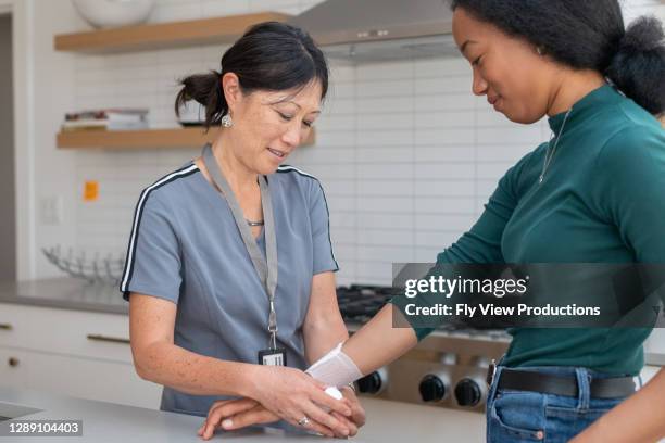 healthcare working visiting injured patient at home - injured hand stock pictures, royalty-free photos & images