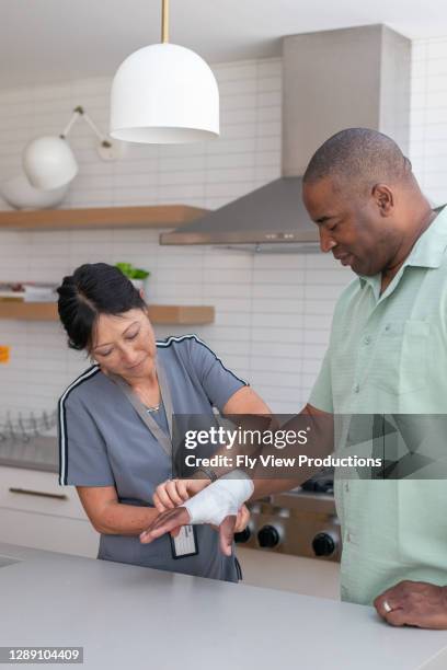 le docteur rend visite au patient avec le poignet blessé à son domicile - occupational therapy kitchen photos et images de collection