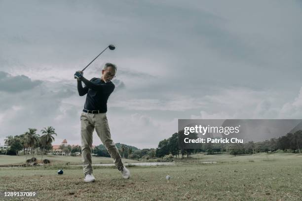 asiatische chinesische reife mann golfer bereitet sich auf abschlag auf golfplatz - abschlagen stock-fotos und bilder
