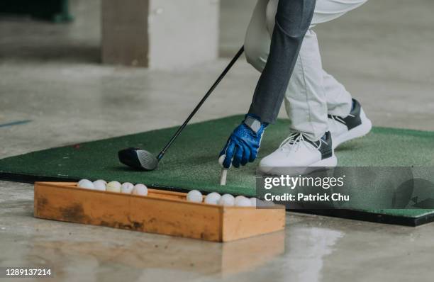 fechar-se da mão do golfista colocando bola de golfe no tee no alcance de condução - golf clubhouse - fotografias e filmes do acervo