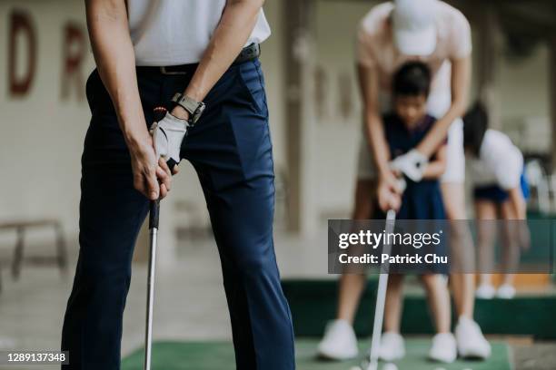 close-up van de hand van golfer die golfclub bij drijfwaaiergolfcursus houdt - drivingrange stockfoto's en -beelden