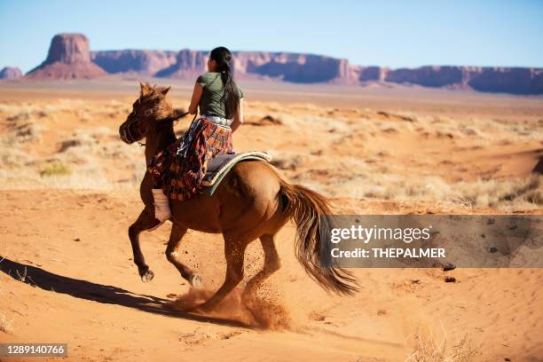 navajo woman riding her horse at monument valley usa - horseback riding arizona stock pictures, royalty-free photos & images