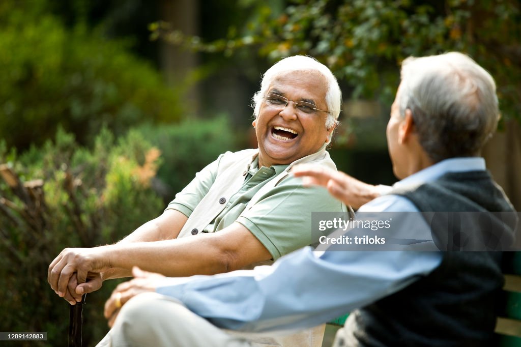 Two senior men discussing on park bench