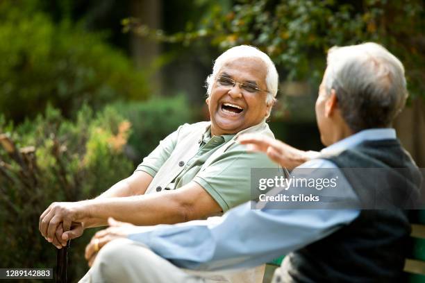 två äldre män diskuterar på parkbänk - two happy people portrait bildbanksfoton och bilder