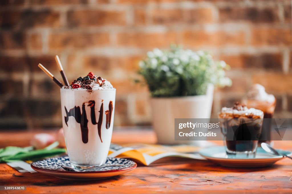 Un verre de milkshake à la vanille avec de la crème fouettée et des chocolats