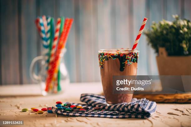 choklad milkshake med papper sugrör på rustik tabell - chocolate smoothie bildbanksfoton och bilder