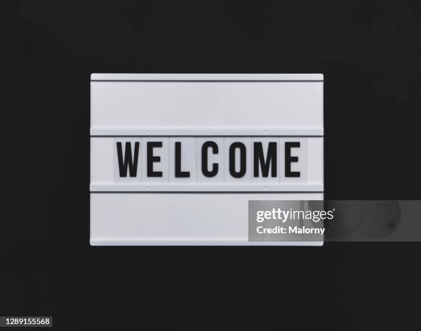 welcome sign. black background. - panneau de bienvenue photos et images de collection