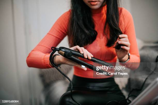 woman using hair straightener at home - flat iron stock pictures, royalty-free photos & images