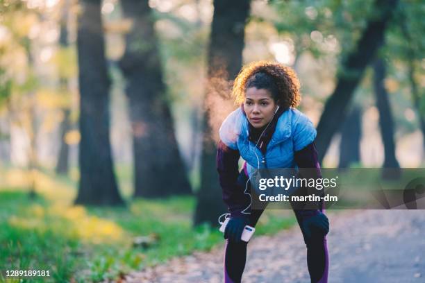 de sportenopleiding van de vrouw in het park - runner tired stockfoto's en -beelden