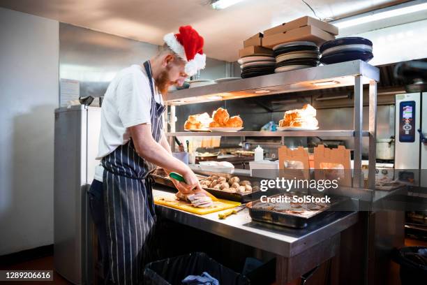 chef utilisant le chapeau de santa tout en préparant le dîner de noël - accompagnement professionnel photos et images de collection