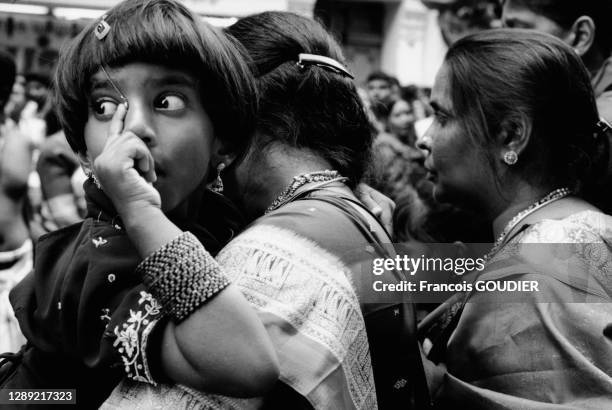 Petite fille dans les bras de sa mère lors de la fête de Ganesh rue Philippe de Girard dans le 18ème arrondissement de Paris le 07 septembre 2003,...