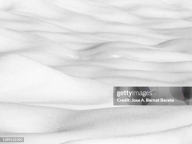 background, full frame of snow covered ground with wavy forms produced by the wind. - neige fraîche photos et images de collection