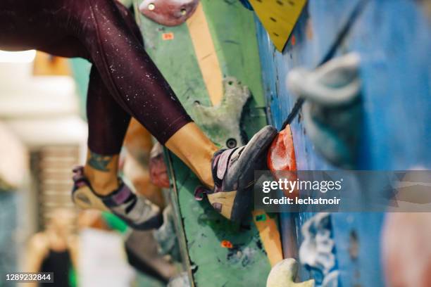 pernas em uma parede de escalada de pedregulho - bouldering - fotografias e filmes do acervo