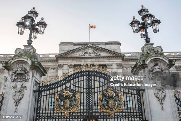 Royal Coat of Arms and the gates at Buckingham Palace, London, England.