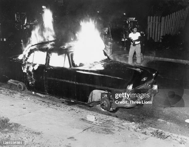 Fireman looking startled as snipers fire on him and his colleagues as they approach a burning car in Detroit, Michigan, July 1967. Violence erupted...