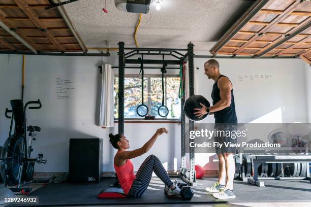 mujer haciendo ejercicio con entrenador personal en el gimnasio del hogar - mature coach fotografías e imágenes de stock