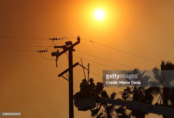 Workers repair power lines damaged during the Bond Fire in the Silverado Canyon area of Orange County on December 3, 2020 near Irvine, California....