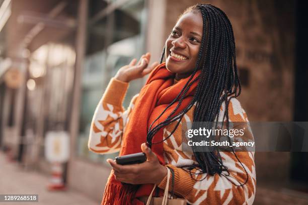 uma mulher afro-americana alegre cumprimentando alguém na rua - beautiful south african women - fotografias e filmes do acervo