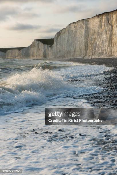 waves on the beach at the seven sisters cliffs, east sussex, uk - seven sisters cliffs stock pictures, royalty-free photos & images