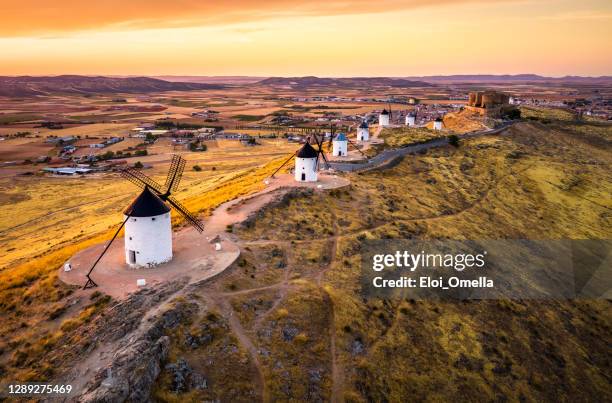 moulins à vent de consuegra au coucher du soleil. castilla la mancha, espagne - structure actionnée par le vent photos et images de collection