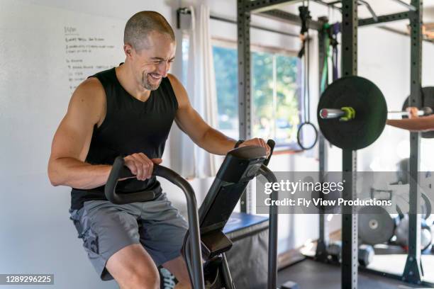 muscular man doing workout on exercise bike - gym covid stock pictures, royalty-free photos & images
