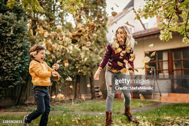 mutter und sohn spielen im hinterhof mit gartengeräten - gartenhaus stock-fotos und bilder