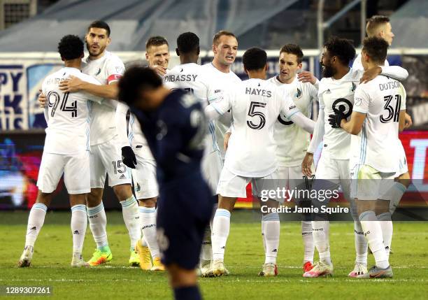 Minnesota United players congratulate each other after defeating Sporting Kansas City 3-0 to win the MLS playoff game at Children's Mercy Park on...