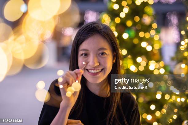 young woman enjoying with christmas lights after work - work lights led stock pictures, royalty-free photos & images