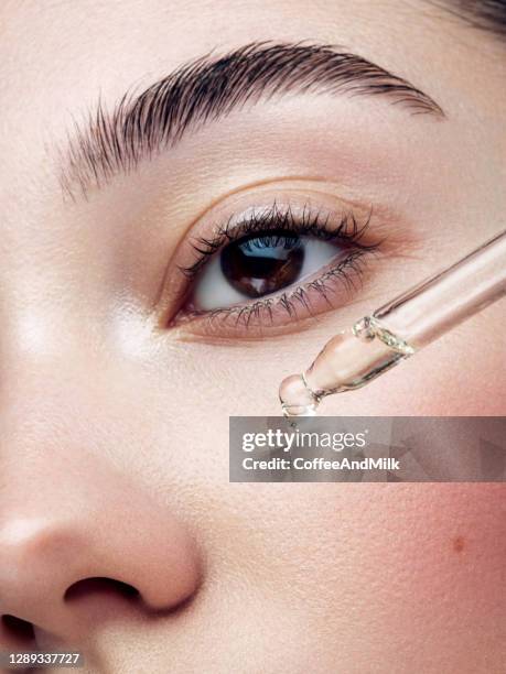 close-up portrait of beautiful girl getting skin anti aging treatment - applying oil stock pictures, royalty-free photos & images