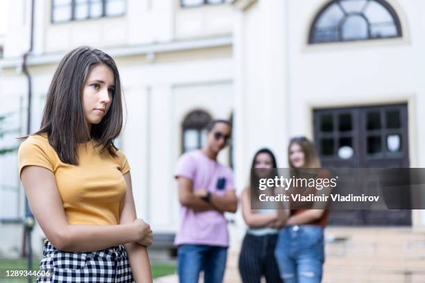 klassenkameraden schikanieren ein mädchen auf dem schulhof - bully school stock-fotos und bilder