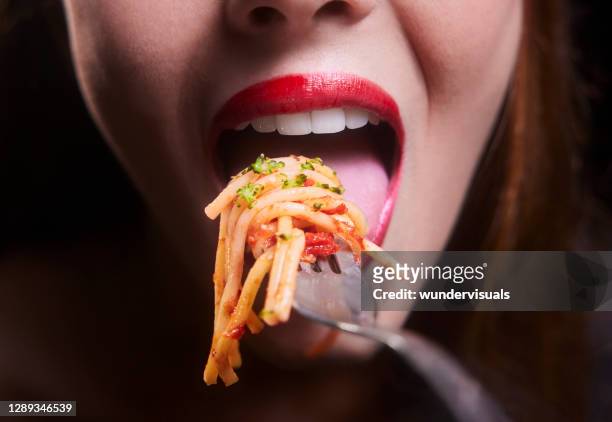 young woman mouth eating spaghetti pasta bolognese on a silver fork - woman eat noodles imagens e fotografias de stock
